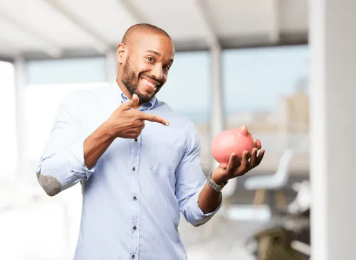 A man holding a piggy bank and pointing to it.